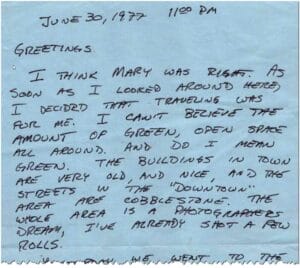 A handwritten note on blue paper dated June 30, 1977, at 11:00 PM. The writer describes scenic surroundings, old town buildings, cobblestone streets, and mentions taking several photos.