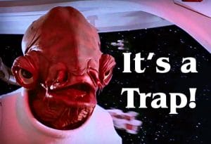 A close-up of Admiral Ackbar, a character from Star Wars, with the phrase 'It's a Trap!' in large white text beside him. The background shows a spaceship interior and outer space.