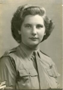 Black-and-white portrait of a young woman in military uniform with insignia, gazing at the camera with neat hair and a composed expression.