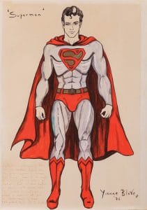 Illustration of Superman in a red and gray costume with red boots, trunks, belt, and cape, and a stylized S on his chest. The drawing is signed Yvonne Blake 76 and includes handwritten notes.