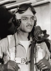 A young Black pilot in vintage flight gear holds parachute straps, an oxygen mask hanging down, gazing confidently into the distance.