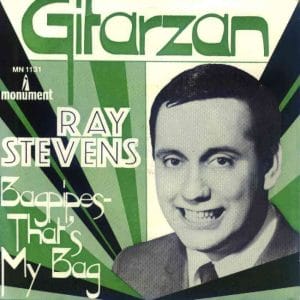 Vintage 45 RPM record sleeve with the title Gitarzan and Ray Stevens in bold letters. Below, it reads Bagpipes - That's My Bag to denote the B side. The cover features a black-and-white photo of Ray Stevens smiling. Green geometric background.