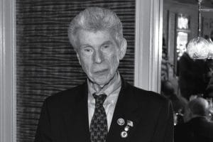 An older man in coat and tie.