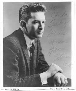 An autographed black-and-white portrait of a man in a suit, arms crossed on a table. Text below notes 'Warren Storm, Nasco Recording Artist.'