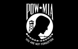 Black and white POW*MIA logo with a silhouette of a mans head, a guard tower, and barbed wire. Text above reads POW*MIA and below says You Are Not Forgotten.