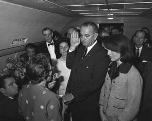 Lyndon B. Johnson takes the presidential oath of office on Air Force One, surrounded by officials and Jacqueline Kennedy, soon after the assassination of John F. Kennedy in 1963.